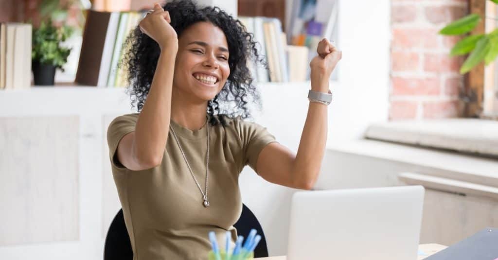 American woman sit at desk feel euphoric win online lottery