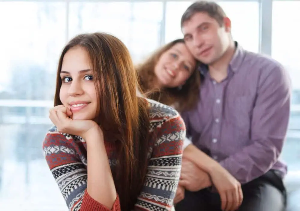 teenage girl sitting in front of her parents