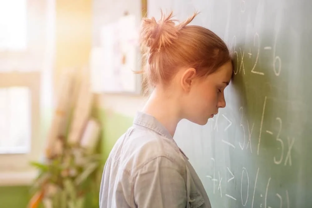 girl in math class overwhelmed by the math formula