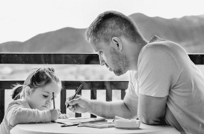 girl studying with father