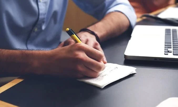 man writing a note