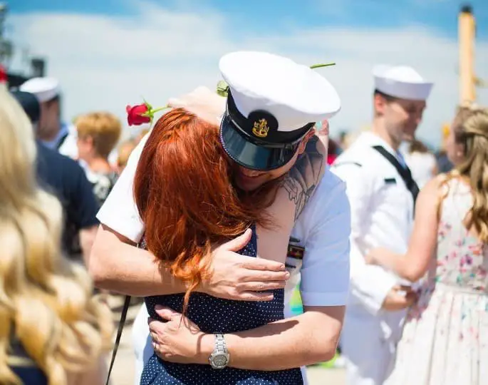 naval officer hugging his daughter