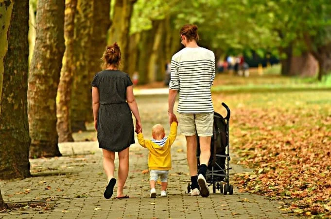 parent taking kid for a walk