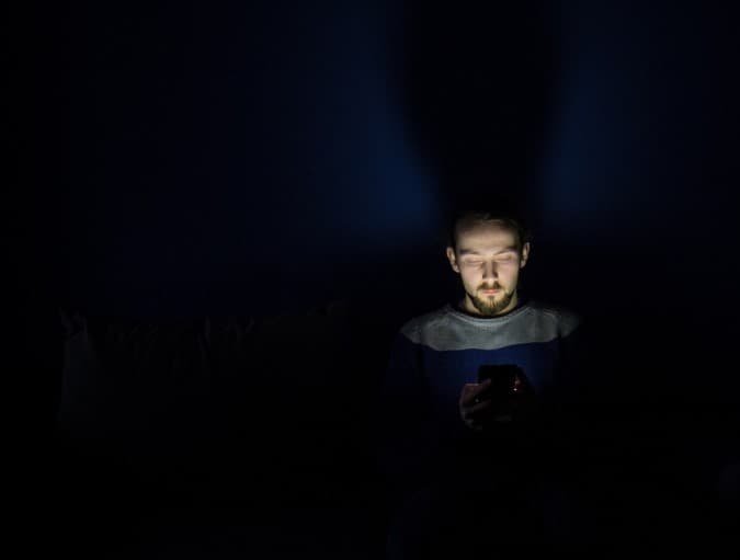 man using mobile in dark