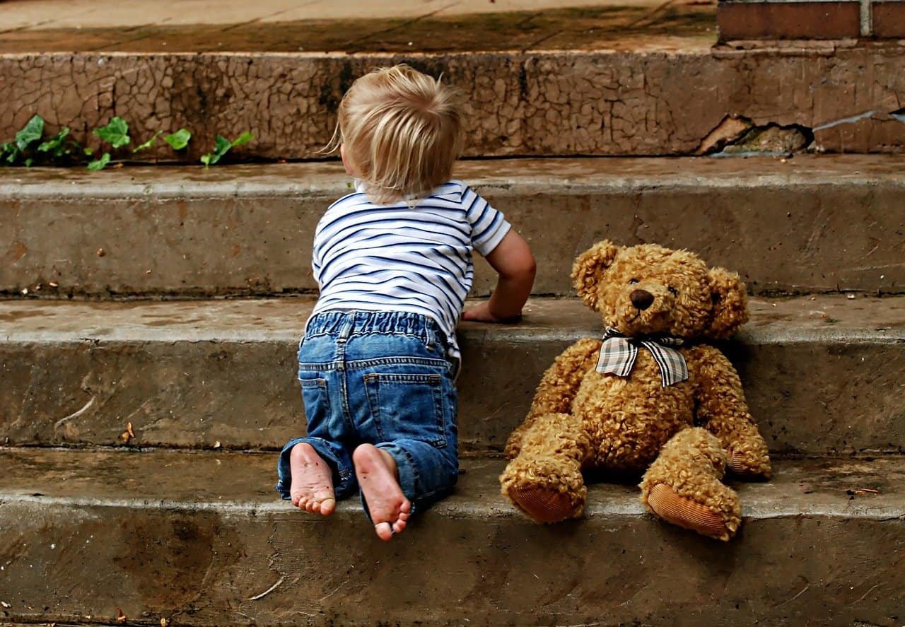 baby with teddy bear on stairs