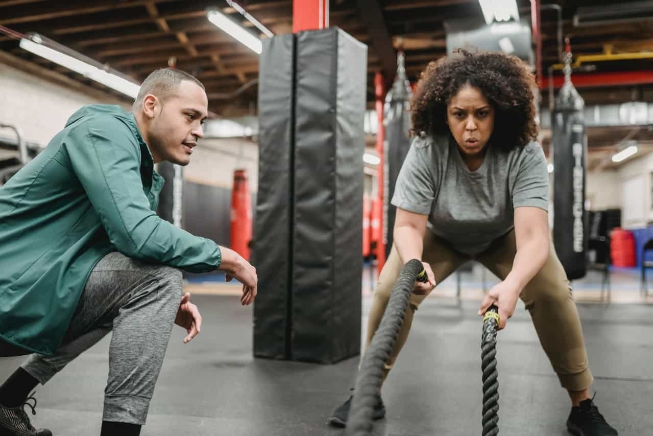 young black women exercise with battle ropes
