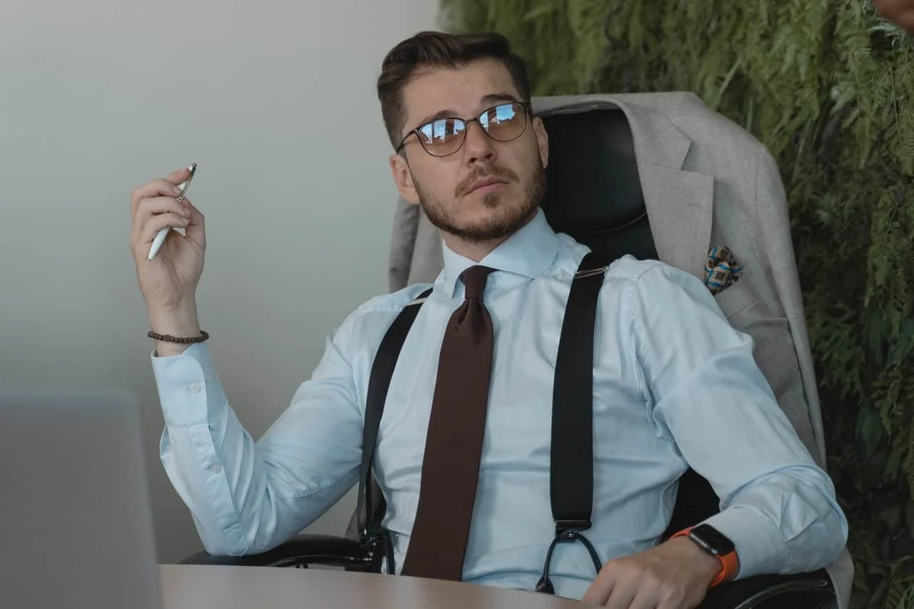 bearded man sitting in office and listening to his staff