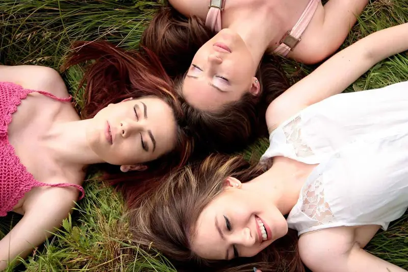 girls lying on grass outdoor during day time