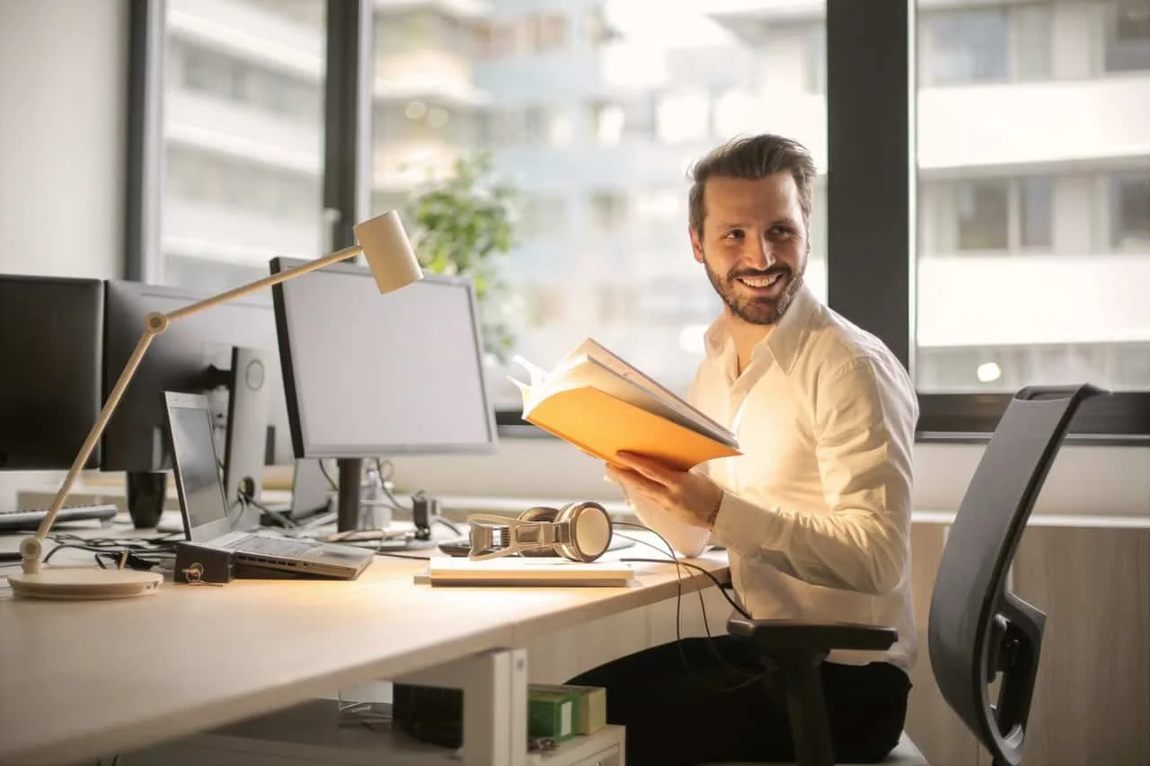 man holding book during work in his office