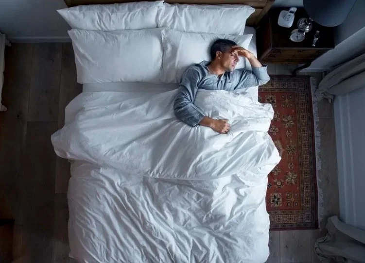 man in bed unable to sleep