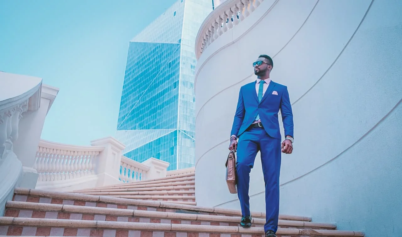 man in blue suit standing on stairs