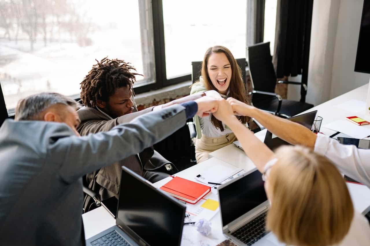 triumphant colleagues in office meeting room