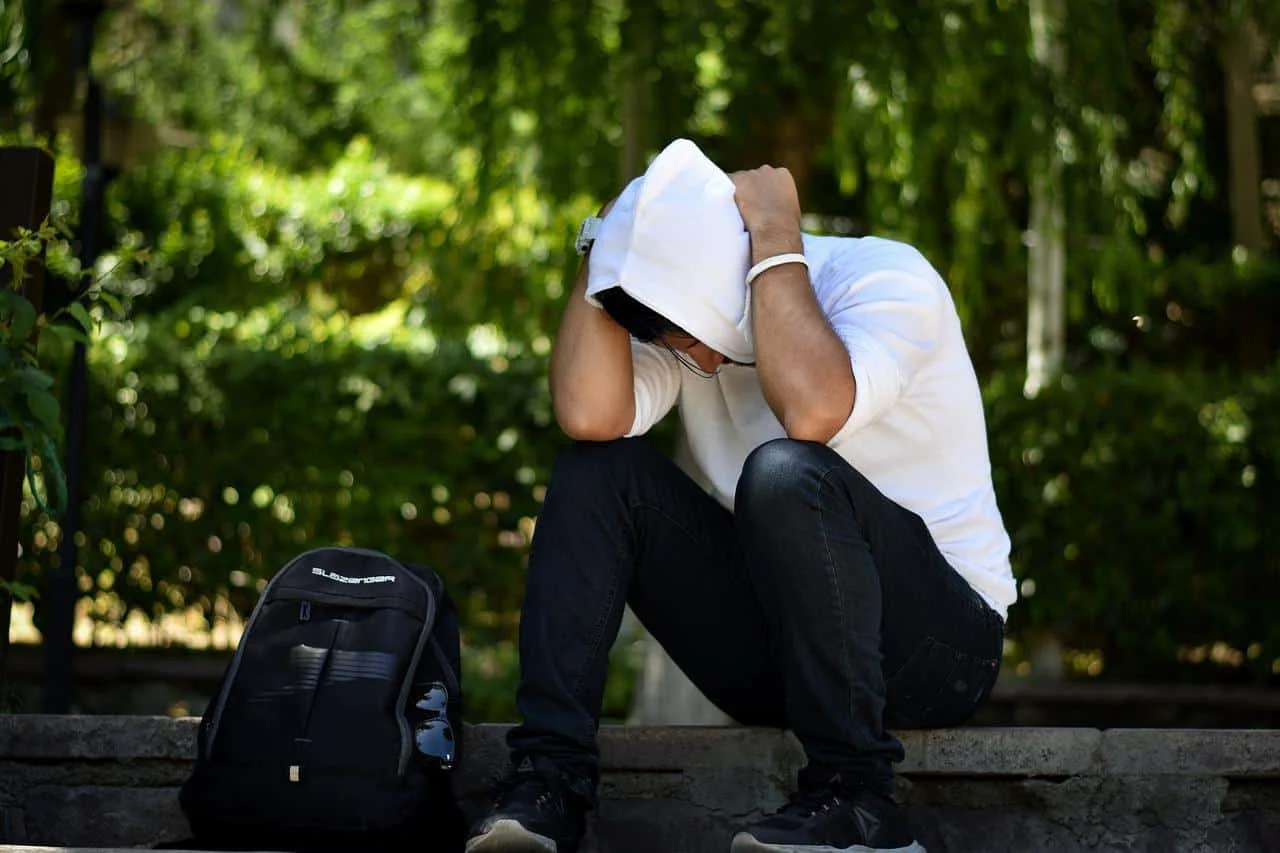 upset man sitting on road side