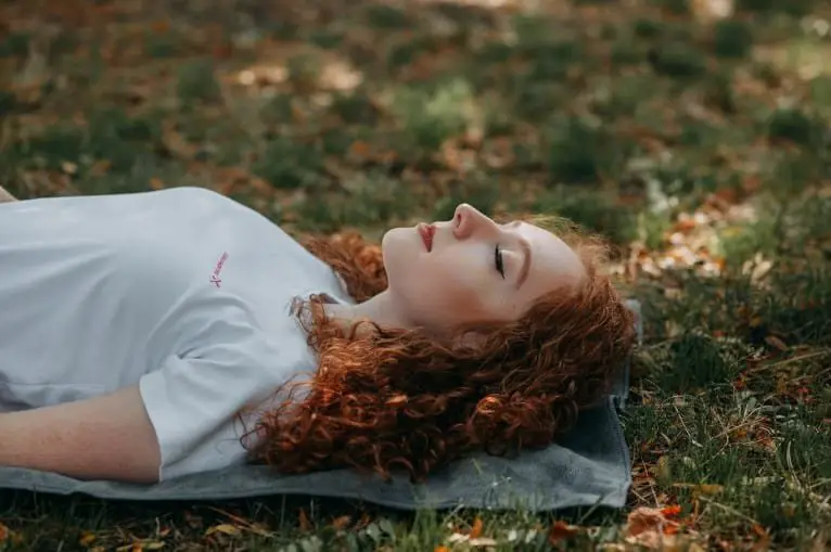 woman lying on the grass with eyes closed