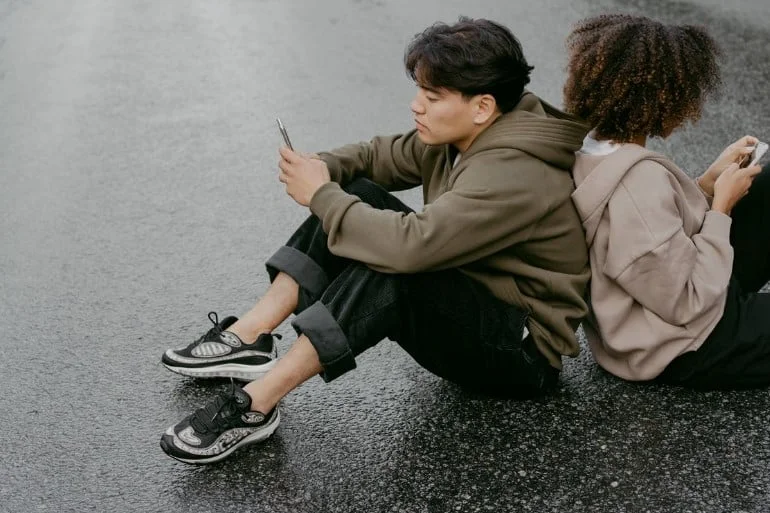 couple checking their phones and having their back to each other