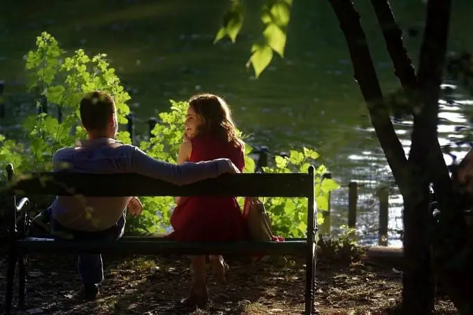 couple sitting on a bench by a lake