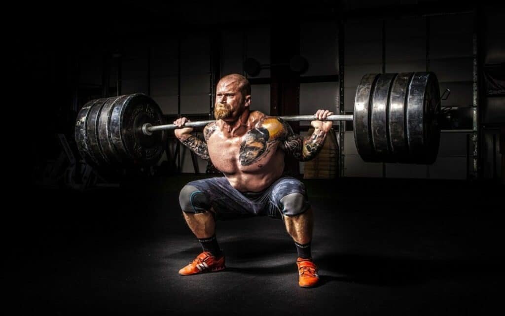 man lifting barbell with heavy weights