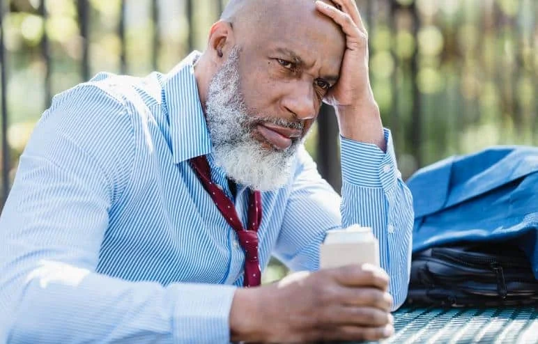 sad man with a worried look drinking beverage