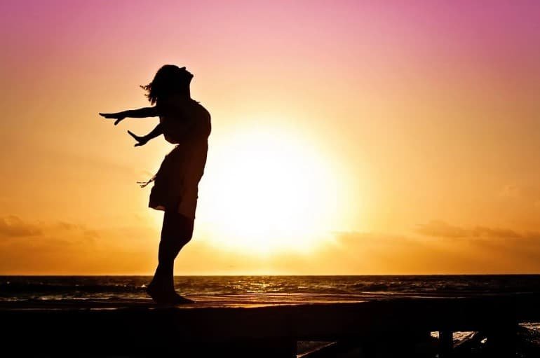 silhouette of a lady by the beach during sunset