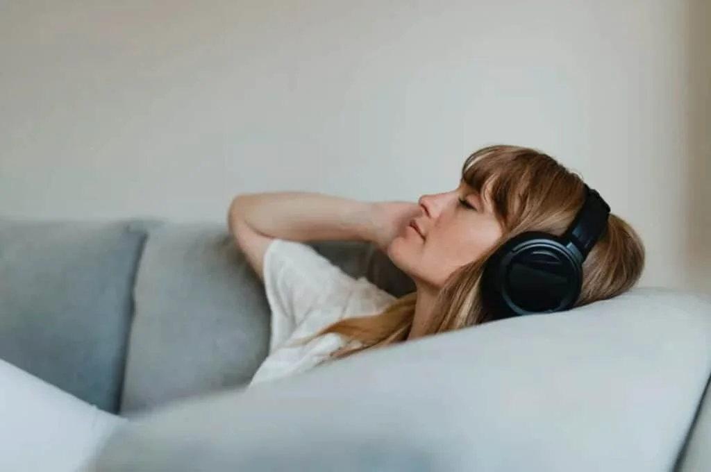 woman with headphones relaxing on a couch