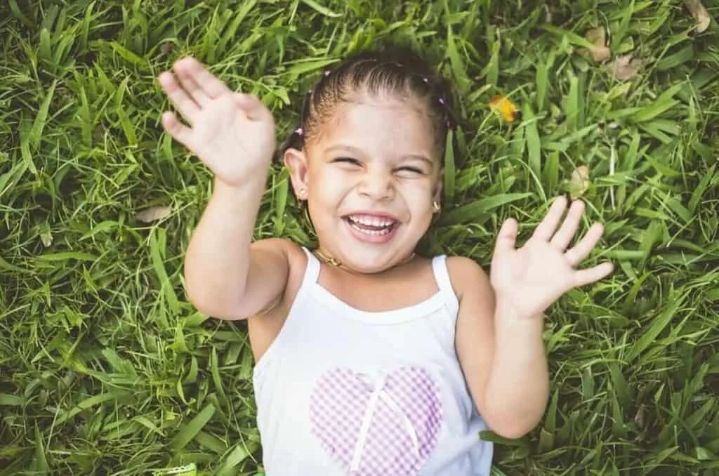 girl with a warm smile lying on the grass