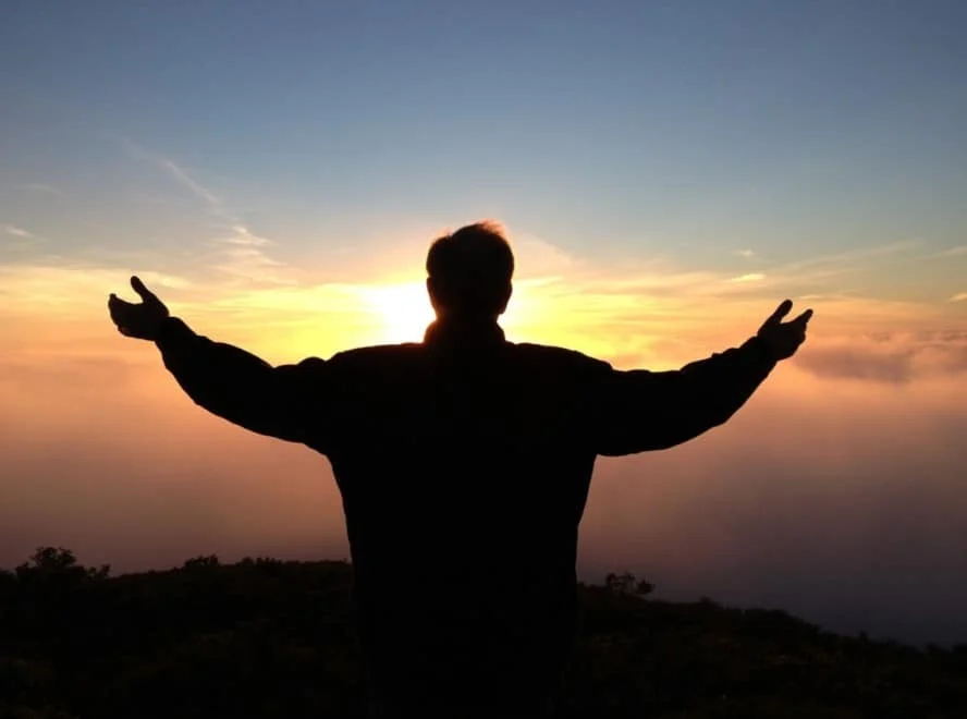 man spreading his arms to the sky