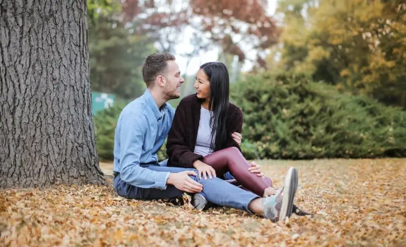 happy couple sitting under a tree