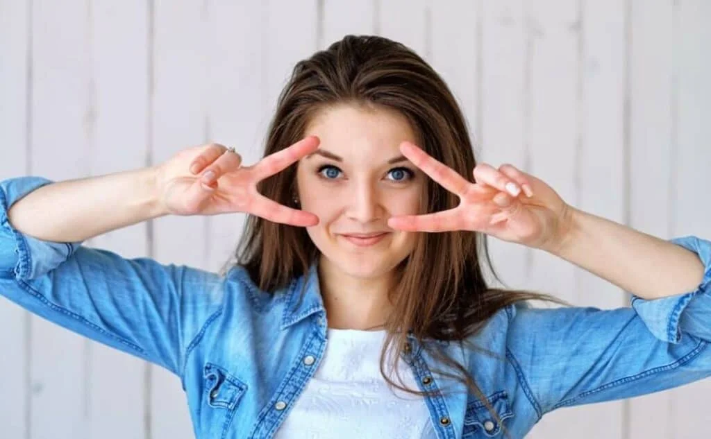 woman making sideways peace signs with both hands