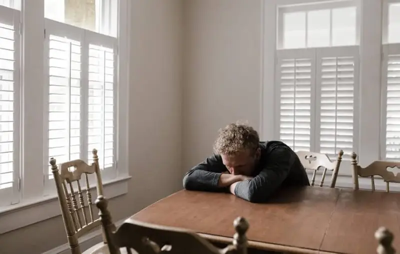 worried man resting on desk