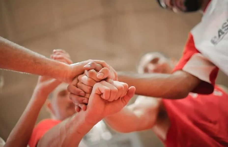 basketball team joining hands