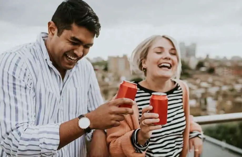 couple sharing coke and smiling