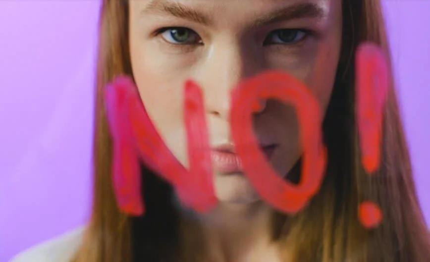 girl standing near glass saying no