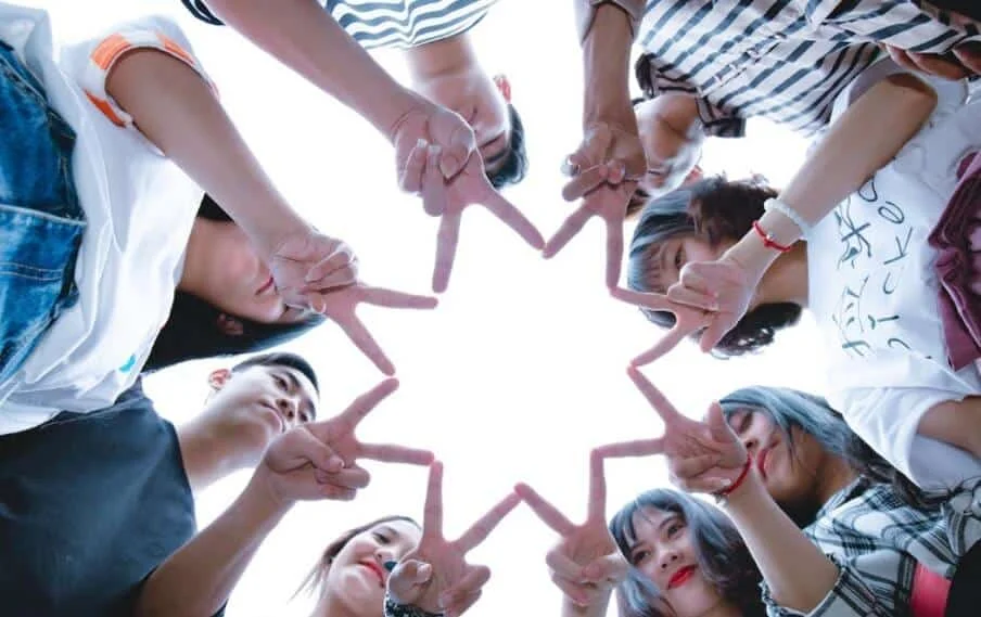 group of friends forming star with fingers