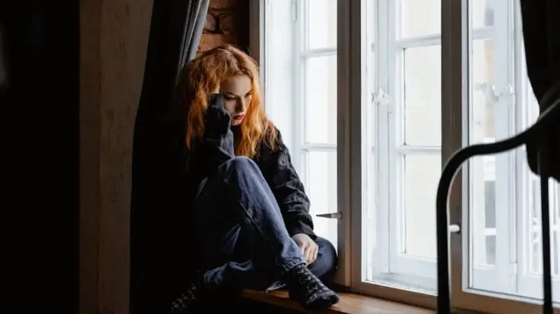 sad women sitting near a window