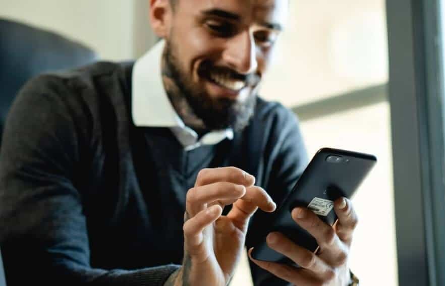 smiling man texting