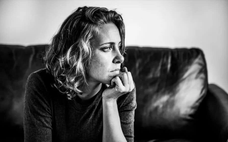 woman in a pensive mood sitting on a couch