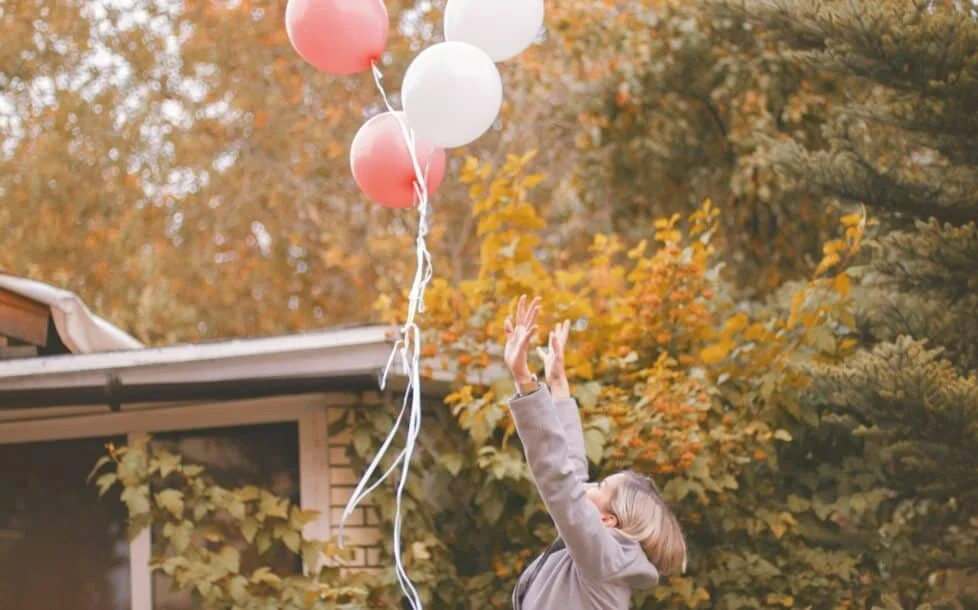 woman releasing balloons into the air