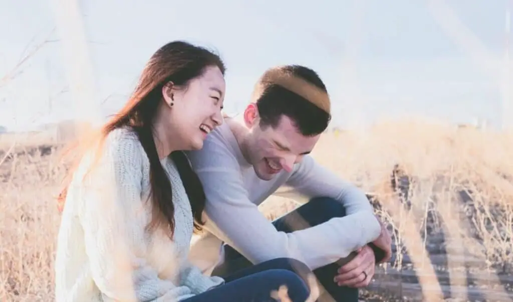 couple laughing on railway track