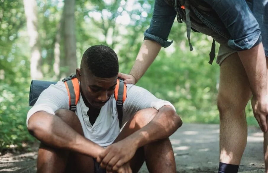 friend helping tired hiker