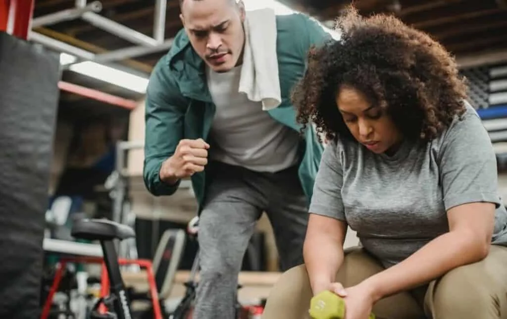 man motivating women in the gym