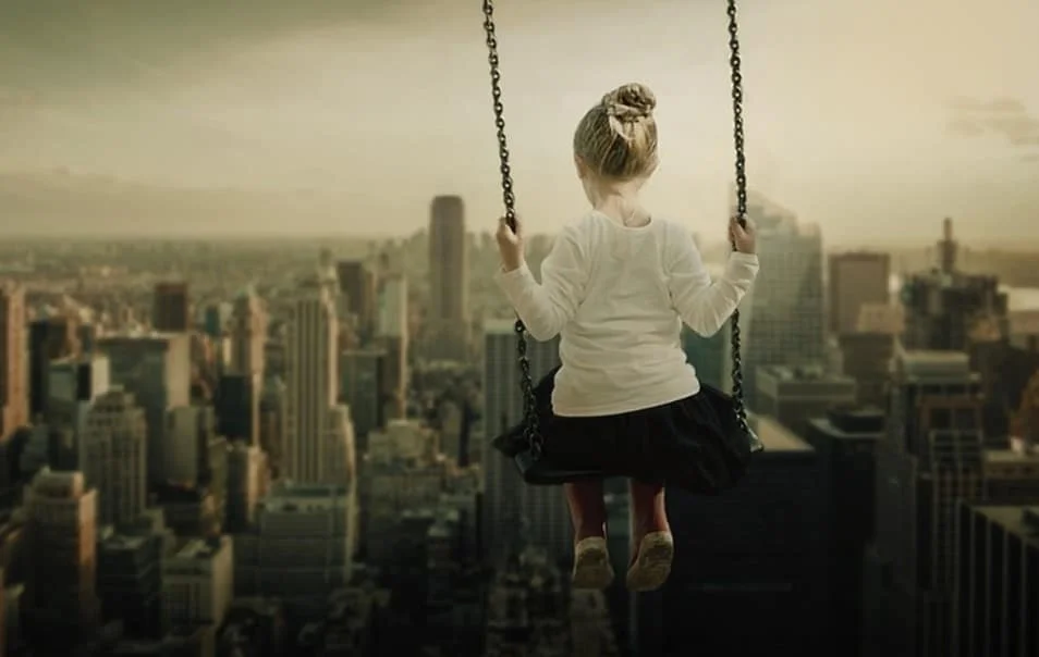 girl on a swing against skyline background