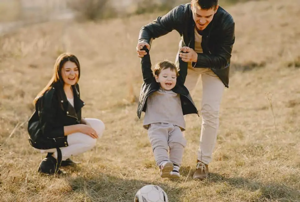 parents playing soccer with child