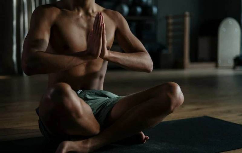 shirtless man in a meditative pose