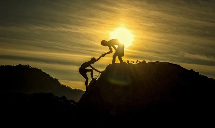 man helping another man climb