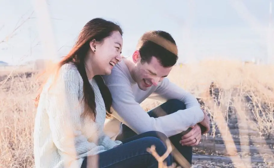 couple on a train track laughing
