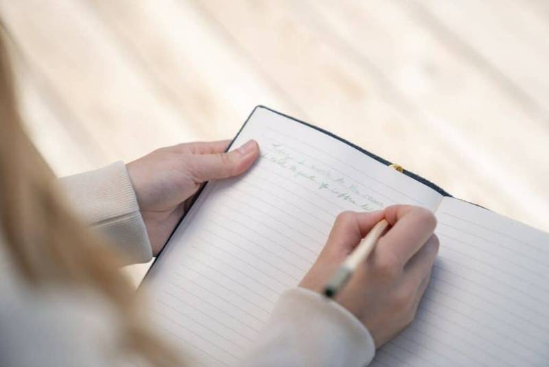 A person writing in a notebook