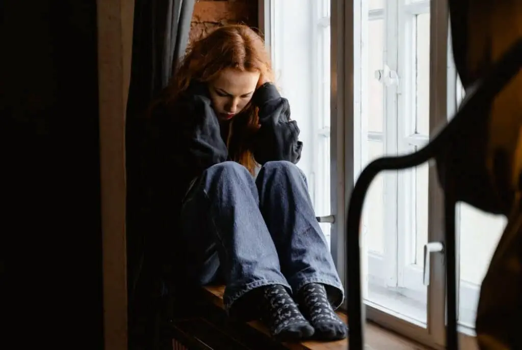 Sad woman sitting by the window