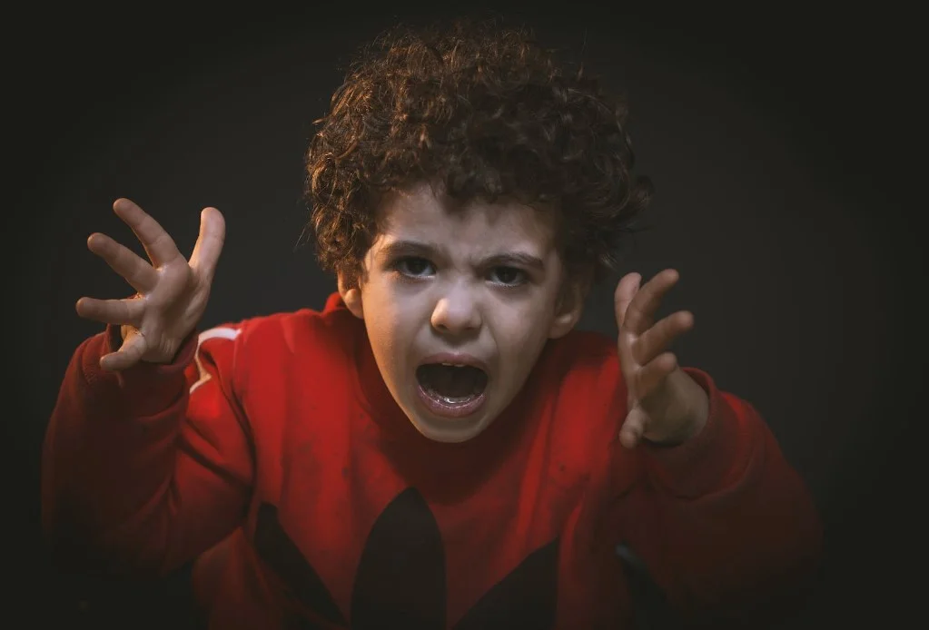 Boy in red shirt showing frustration