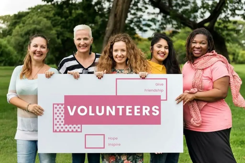 Group of volunteers holding a sign