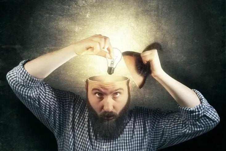 Man putting a lightbulb inside his head